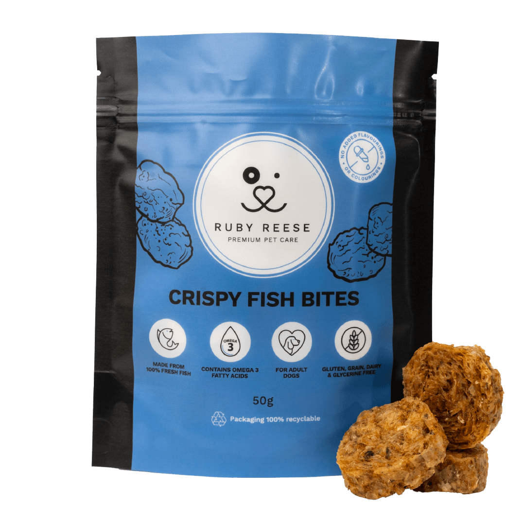 A blue pouch of RUBY REESE CRISPY FISH BITES natural dog treats with a ziplock and a CRISPY FISH BITE lying in front of it