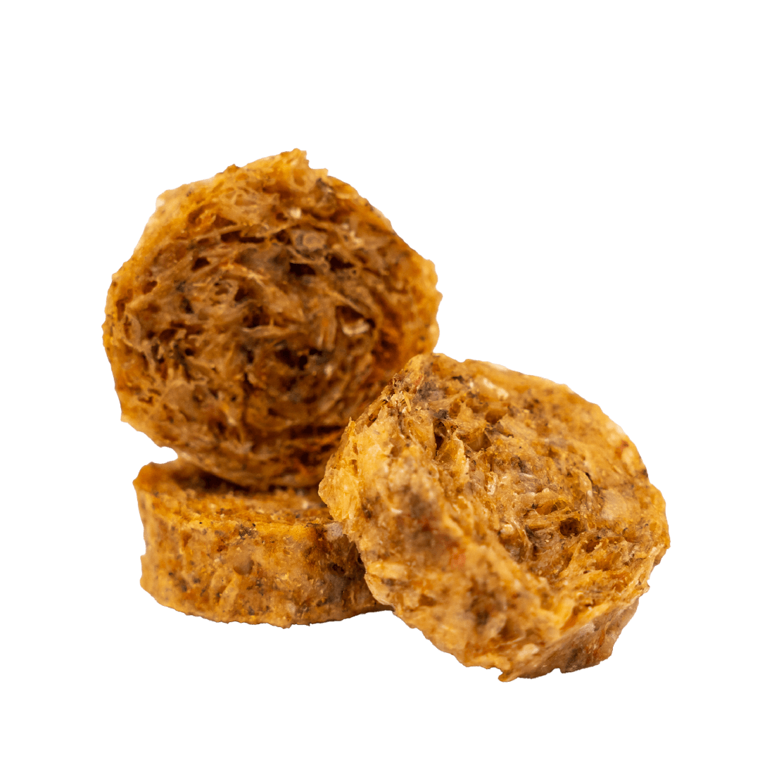 A group of three RUBY REESE CRISPY FISH BITES stacked on each other. They are round red dog treats made from 100% fish skin